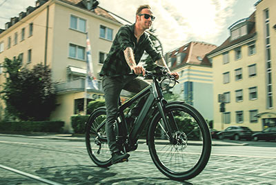 Man ser en mand på en Winora-cykel, der cykler gennem bymidten.