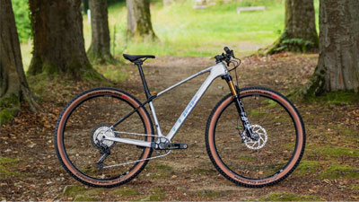 Her ses en sølvfarvet Cube-mountainbike på en skovvej.