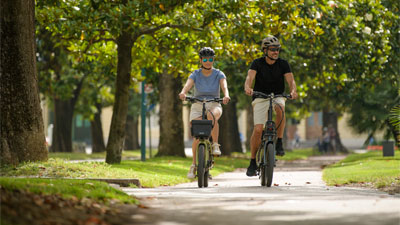 Et par cykler gennem en park på deres foldecykler.