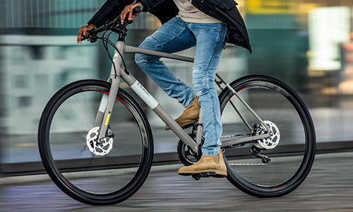 En cyklist kører gennem byen på sin motionscykel; cyklisten er kun delvist synlig.