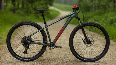 Her ses en grå Cube-mountainbike med røde detaljer på en grusvej.